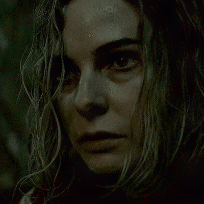 A Close Up Of A Woman 'S Face In The Dark GIF
