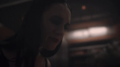 A Close Up Of A Woman 'S Face In The Dark GIF