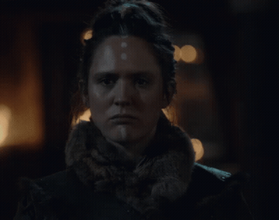 A Close Up Of A Woman 'S Face In The Dark GIF