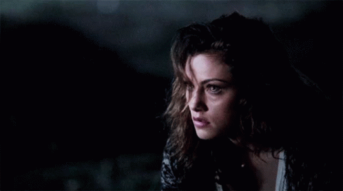A Close Up Of A Woman 'S Face In The Dark GIF