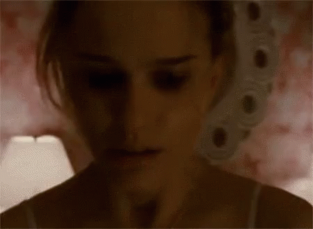 A Close Up Of A Woman 'S Face In The Dark With A Lamp In The Background . GIF