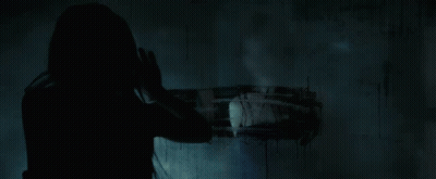 A Close Up Of A Woman 'S Face In The Dark With Her Mouth Open GIF
