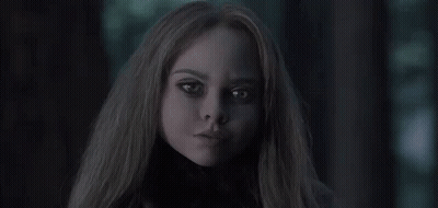 A Close Up Of A Woman 'S Face In The Dark With Long Hair . GIF
