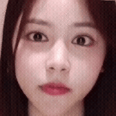 A Close Up Of A Woman 'S Face Making A Funny Face With Her Eyes Closed . GIF