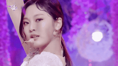 A Close Up Of A Woman 'S Face On A Purple Background . GIF