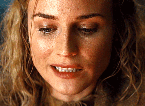 A Close Up Of A Woman 'S Face Showing Her Teeth GIF