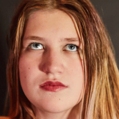 A Close Up Of A Woman 'S Face Shows Her Blue Eyes And Red Lips GIF