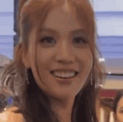 A Close Up Of A Woman 'S Face Smiling With A Blurry Background . GIF