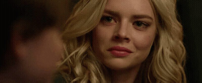 A Close Up Of A Woman 'S Face Smiling With A Man Behind Her . GIF