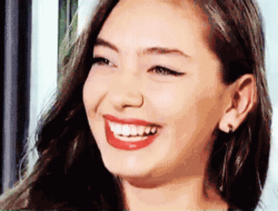A Close Up Of A Woman 'S Face Smiling With Red Lips GIF