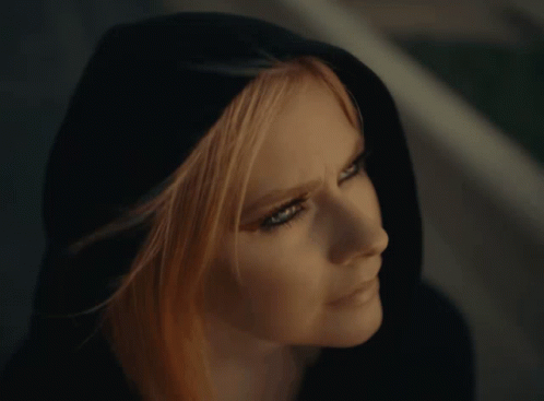 A Close Up Of A Woman 'S Face Wearing A Black Hood GIF
