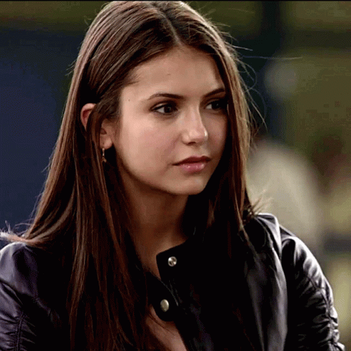 A Close Up Of A Woman 'S Face Wearing A Black Leather Jacket GIF