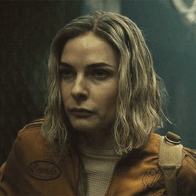 A Close Up Of A Woman 'S Face Wearing A Brown Jacket GIF