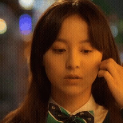 A Close Up Of A Woman 'S Face Wearing A Green Bow Tie GIF