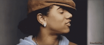 A Close Up Of A Woman 'S Face Wearing A Hat And Earrings GIF