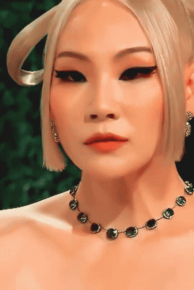 A Close Up Of A Woman 'S Face Wearing A Necklace GIF