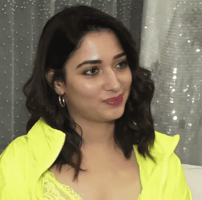 A Close Up Of A Woman 'S Face Wearing A Neon Yellow Jacket GIF