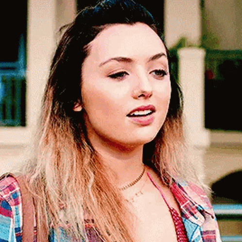 A Close Up Of A Woman 'S Face Wearing A Plaid Shirt And A Choker . GIF