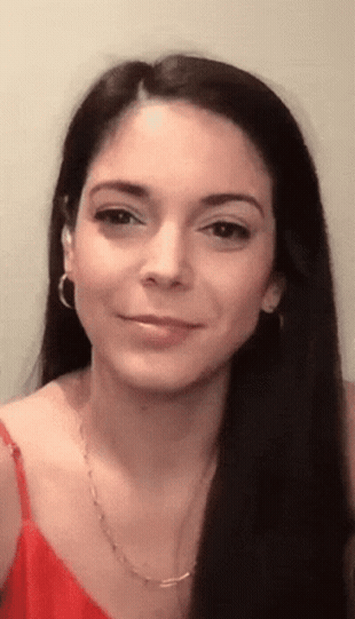 A Close Up Of A Woman 'S Face Wearing A Red Tank Top And Earrings GIF