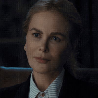 A Close Up Of A Woman 'S Face Wearing A Striped Shirt And A Black Jacket GIF