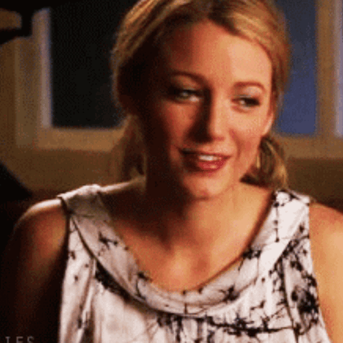 A Close Up Of A Woman 'S Face Wearing A Tie Dye Tank Top . GIF