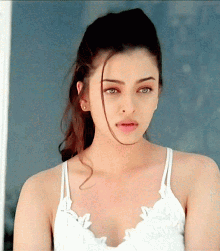 A Close Up Of A Woman 'S Face Wearing A White Top GIF