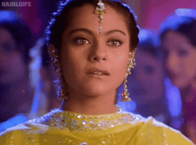 A Close Up Of A Woman 'S Face Wearing A Yellow Dress And Earrings GIF