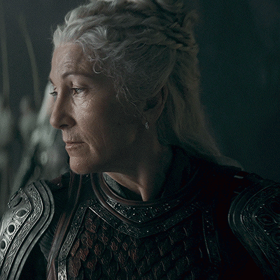 A Close Up Of A Woman 'S Face Wearing Armor And Earrings GIF