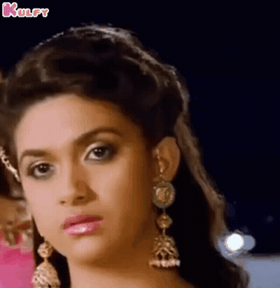 A Close Up Of A Woman 'S Face Wearing Earrings And A Crown . GIF