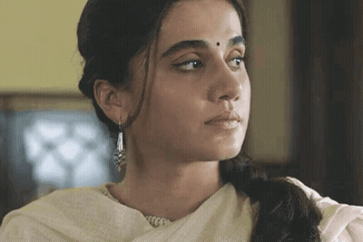 A Close Up Of A Woman 'S Face Wearing Earrings And A White Dress GIF
