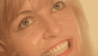 A Close Up Of A Woman 'S Face With A Big Smile GIF