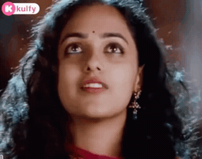A Close Up Of A Woman 'S Face With A Bindi On Her Forehead Looking Up . GIF