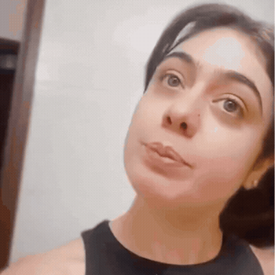 A Close Up Of A Woman 'S Face With A Black Tank Top GIF