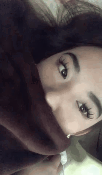 a close up of a woman 's face with a blanket covering her mouth .