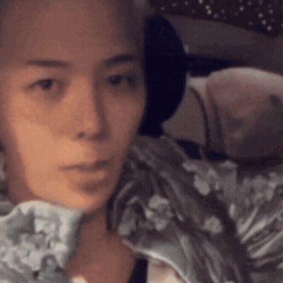 A Close Up Of A Woman 'S Face With A Blanket On Her Shoulder GIF