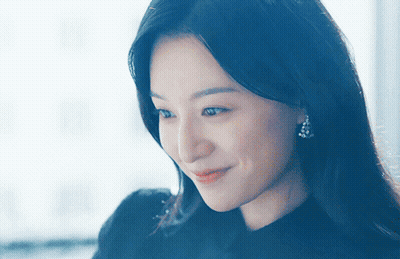 A Close Up Of A Woman 'S Face With A Blue Background GIF