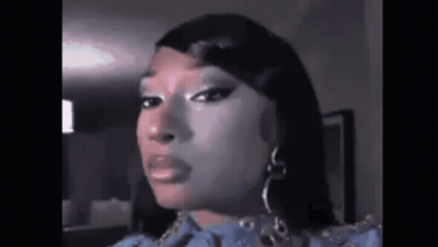 A Close Up Of A Woman 'S Face With A Blue Dress And Earrings . GIF