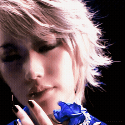 A Close Up Of A Woman 'S Face With A Blue Flower In Her Hand And The Word Eclectic On The Bottom GIF