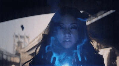 A Close Up Of A Woman 'S Face With A Blue Light Coming Out Of Her Hands GIF