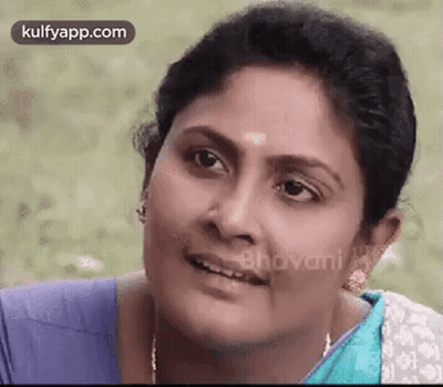 A Close Up Of A Woman 'S Face With A Blue Shirt On . GIF