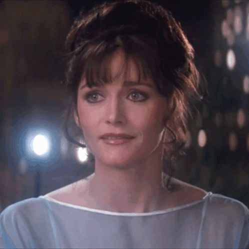 A Close Up Of A Woman 'S Face With A Blue Shirt On GIF