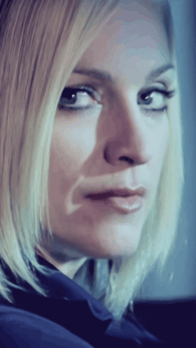 A Close Up Of A Woman 'S Face With A Blue Shirt On GIF