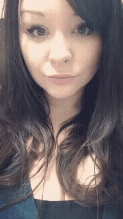 A Close Up Of A Woman 'S Face With A Blue Shirt On GIF