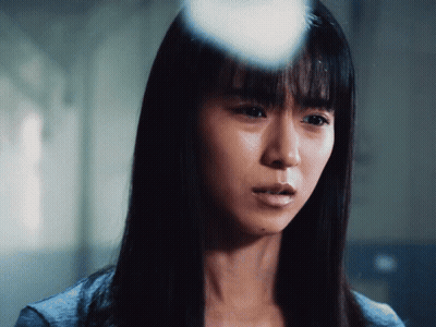A Close Up Of A Woman 'S Face With A Blue Shirt On GIF