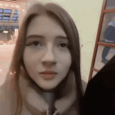A Close Up Of A Woman 'S Face With A Blurred Background . GIF
