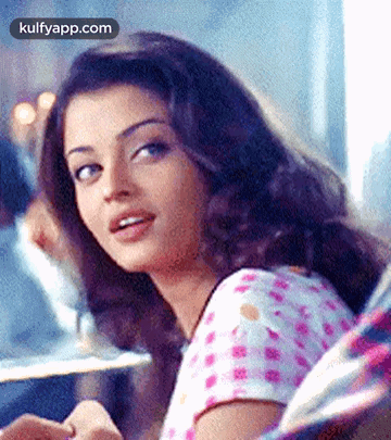 A Close Up Of A Woman 'S Face With A Blurred Background Looking At The Camera . GIF