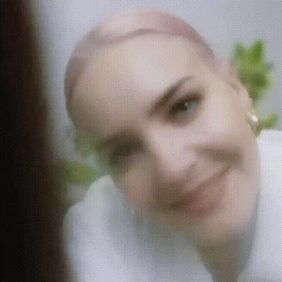 A Close Up Of A Woman 'S Face With A Blurred Background . GIF