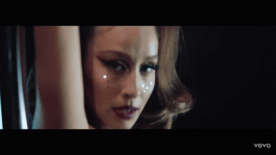 A Close Up Of A Woman 'S Face With A Blurry Background GIF