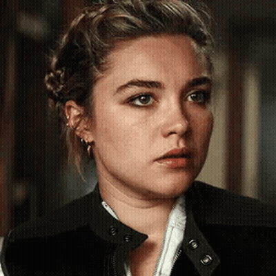 A Close Up Of A Woman 'S Face With A Braid In Her Hair . GIF