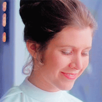A Close Up Of A Woman 'S Face With A Bun And A Smile On Her Face . GIF